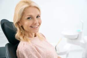 A woman smiling after receiving a dental bridge